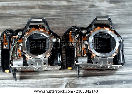 DSLR photographic and video digital camera bodies interior repair by technician or engineer, camera and technology equipment maintenance and repair concept, old SLR crop sensor mirror Cameras fixation