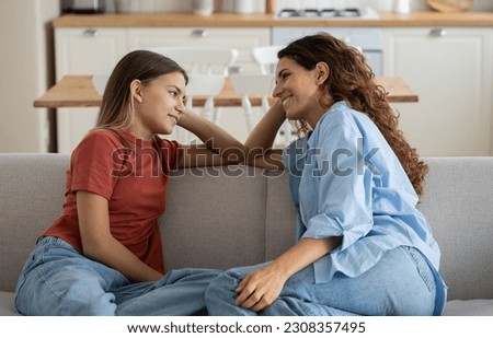 Loving mother listening to daughter with empathy and understanding while sitting together on sofa bonding at home, pre-teen girl child sharing secrets with mom, parent communicating with teenager Royalty-Free Stock Photo #2308357495