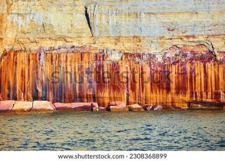Iron streaks in Pictured Rocks with rusty red stone and white-gold minerals and grey colors