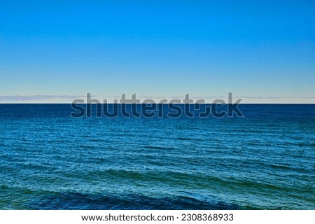 Ocean or lake with gentle blue and green waves at midday