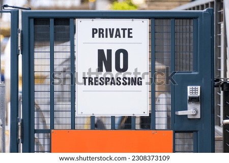 A gate leading into a private area with a sign reading "Private - NO TRESPASSING"