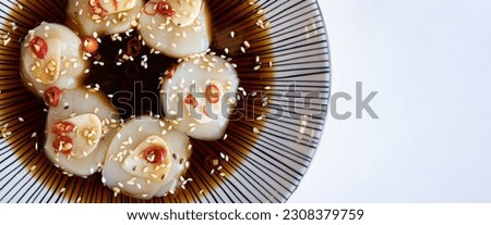 The fresh hotate, or scallop, is a delicious seafood delicacy in Japanese cookery. It can be enjoyed as sashimi, topped with a pickled soy sauce marinade, creating a delightful Asian dish. Royalty-Free Stock Photo #2308379759