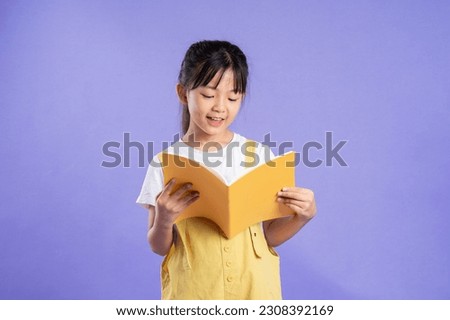 cute asian schoolgirl posing on purple background