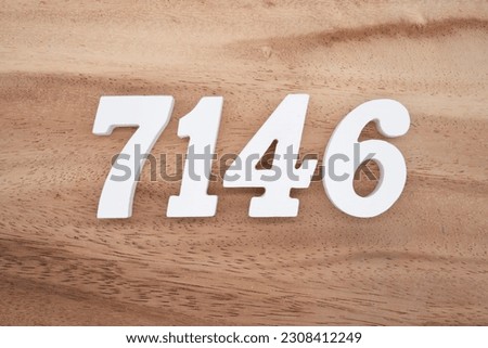 White number 7146 on a brown and light brown wooden background.