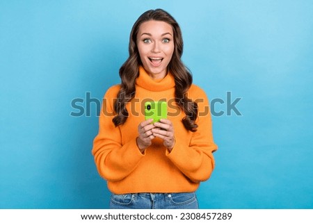 Photo of impressed lovely lady using modern gadget chatting searching incredible discount isolated on blue color background