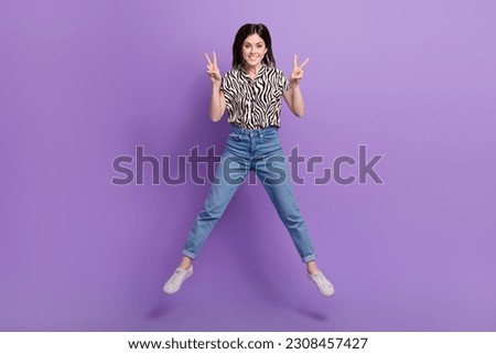 Full size photo of active charming girl jumping demonstrate v-sign isolated on violet color background