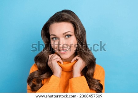 Photo of adorable sweet lady dressed orange pullover smiling arms collar isolated blue color background