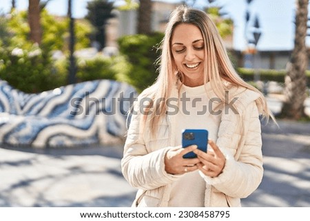 Young woman smiling confident using smartphone at park
