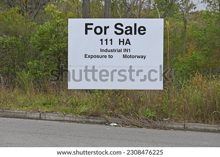 Land for sale sign in front of a bush block