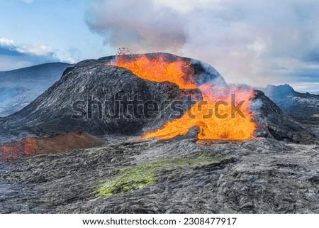 Active volcano on Reykjanes Peninsula. Landscape in Iceland. Lava from the volcanic crater in the day with sunshine. old magma rock at volcanic crater. Rising steam from the crater Royalty-Free Stock Photo #2308477917