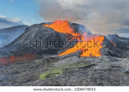 Landscape in Iceland of Reykjanes Peninsula. View of an active volcano with glowing lava. Volcanic crater to erupt during the day with sunshine. cooled magma rock around the crater