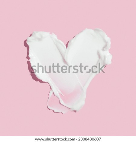 Beauty skincare cream texture swipe swatch in heart shaped. White beauty cream smear smudge isolated on pink background