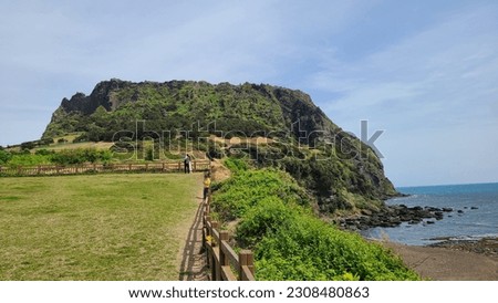 It is Seongsan Ilchulbong Peak in Jeju Island. It is a wonderful view that harmonizes with the sea with beautiful natural scenery. Have a nice picture of Seongsan Ilchulbong in Jeju Island.