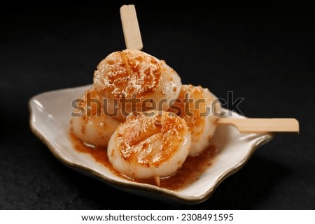 Close up of Grilled scallops skewers with sauces or Hotate Kushiyaki japanese food in a plate on black background. Royalty-Free Stock Photo #2308491595