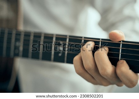 young male musician playing acoustic guitar , Close up classic guitar , finger style . happy mood white background with copy space .