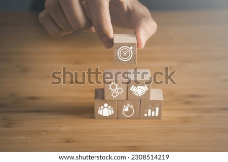 Wooden block with business strategy and goal icons. key performance indicator and businees achievement goal concept.