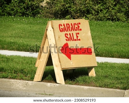 Standing wooden garage sale sign. Directions to yard sale, red arrow. Garage sales are the best.