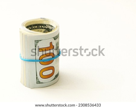 One hundred dollar bills wrapped in a roll tied with a blue rubber band.