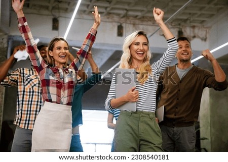 Happy young successful business team celebrating a triumph with arms up in startup office. Royalty-Free Stock Photo #2308540181