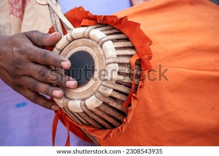 The khol is being played by a devotee. This is a two-sided terracotta drum used in northern and eastern India for accompaniment with devotional music also known as a mridangam. Selective focus Royalty-Free Stock Photo #2308543935