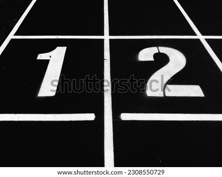 Stadium runway or athlete's track start number (1) (2). Tracks are rubber man-made tracks used in athletics.(Black and white photo) Royalty-Free Stock Photo #2308550729