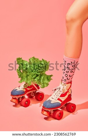 Female leg in vintage rollers and funny socks with lettuce against pink background. Nutrition, healthy eating, diet. Concept of pop art photography, creative vision, imagination. Minimal art