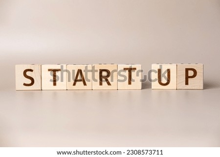 The word START UP on wooden cubes on a beige neutral studio background. Copy Space. Written. Text words matter. Conceptual Photo. Career symbol. The concept of volume increase make business grow.