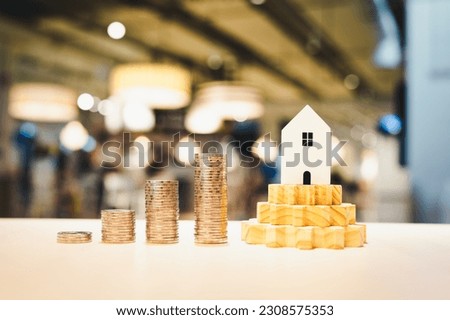 Wood house and row of coin money on wood table and , selective focus, Planning to buy property. Choose what's the best. A symbol for construction ,ecology, loan concepts	
