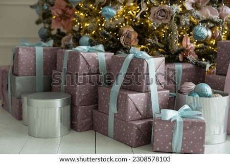 Close-up of Christmas presents in wrapping paper are on the floor under the Christmas tree
