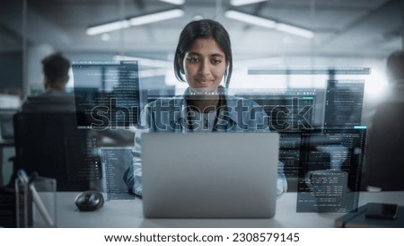 Young Indian Female Software Developer Working in Technological Start-Up Office. South Asian Specialist Programming Monitoring Solutions. VFX Hologram Edit Visualizing Coding Interface, Opened Windows Royalty-Free Stock Photo #2308579145
