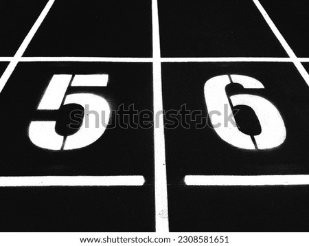 Stadium runway or athlete's track start number (5) (6). Tracks are rubber man-made tracks used in athletics.(Black and white photo)