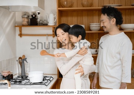 Portrait of an Asian family smiling and laughing in the kitchen Royalty-Free Stock Photo #2308589281
