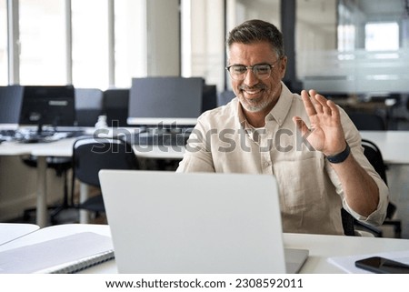 Middle-age Hispanic man using computer remote for business studying, watch online virtual webinar training meeting, video call. Smiling mature Indian or Latin businessman working on laptop in office. Royalty-Free Stock Photo #2308592011