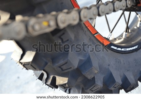 Closeup photo of a dirt bike wheel, focused on the dirt tires