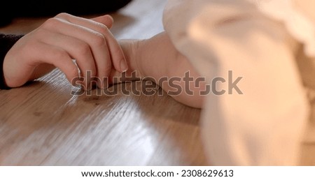 Close-up of mom's hand touching baby's right leg on the floor. Tactile contact between parent and child, mental connection through touch.