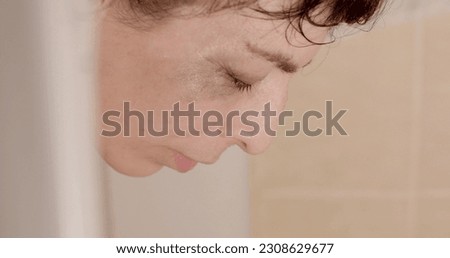 Refresh your face with water. Depressed woman in the bathroom, she finds mental balance to calm down. Deep inner experiences in PMS. Royalty-Free Stock Photo #2308629677