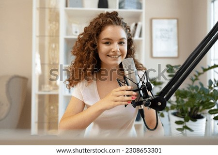 Portrait of happy young female radio host broadcasting in studio