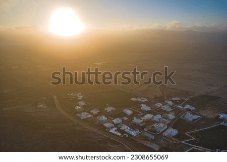 landscape with a small village in the shawdow of the mountain at sunrise taken by drone