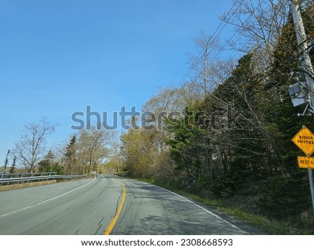 An open highway on a spring morning through a suburban neighborhood area.