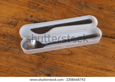 A picture of a pair of spoons and knives in his box 