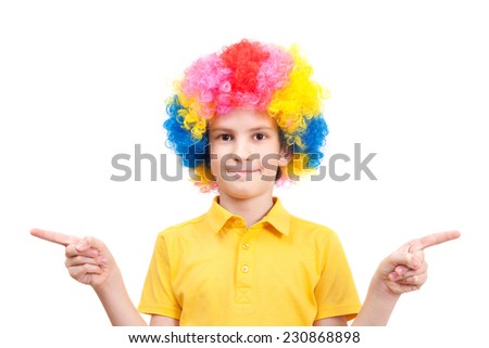 Nice boy in clown dress pointing at sides, isolated on white background 
