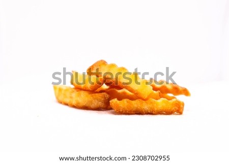 crinkle cut fries that are cooked and ready to eat. Royalty-Free Stock Photo #2308702955