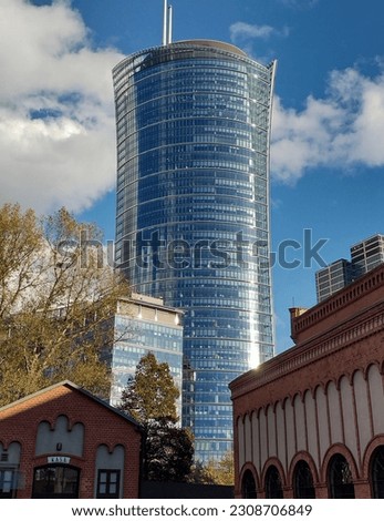 A large glass building in the center of Warsaw, against the blue sky
