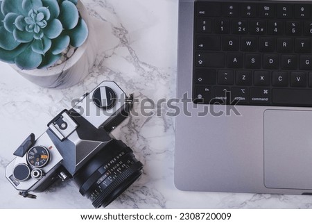 Photographer or stock photography concept, digital black camera near laptop on desk workstation