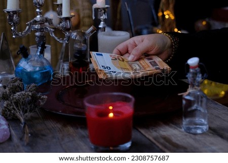 Librate with money, female hands of psychic doing witchcraft passes with euro banknotes, esoteric Oracle performs ritual of removing spell of black magic, esoteric business, magic to increase income Royalty-Free Stock Photo #2308757687