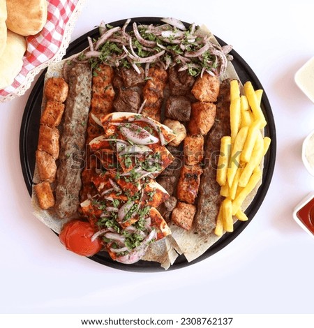 Mix grill on  a black round plate Royalty-Free Stock Photo #2308762137