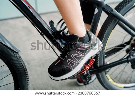 Photo of a girl doing bicycle exercise, and wearing sports shoes   