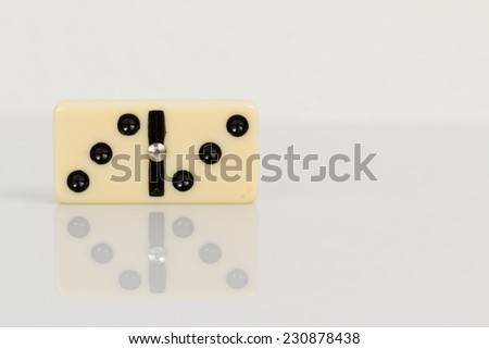 Three Close up of domino pieces with black dots in reflective white background
