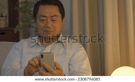 Asian man using smartphone at night