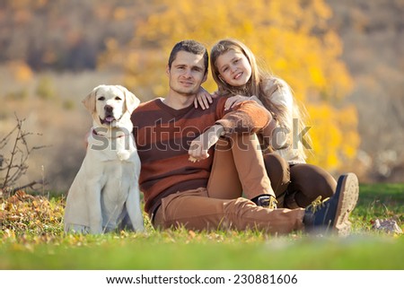 Happy young family spending time outdoor  with their dog